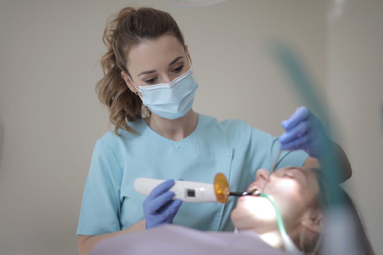 pexels-andrea-piacquadio-3881791 Dentist treating a patient with equipment